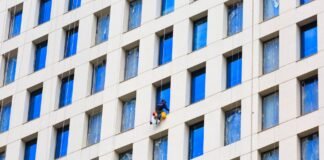 man working at height cleaning the windows in a skyscraper