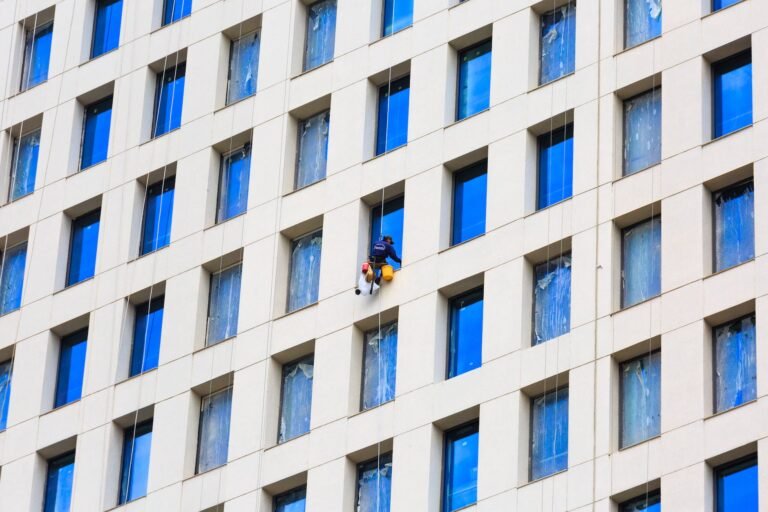 man working at height cleaning the windows in a skyscraper