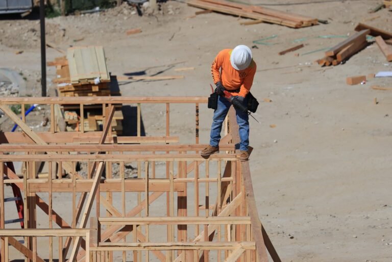 man standing with drill on house construction