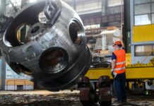 man standing in front of gray metal machine part
