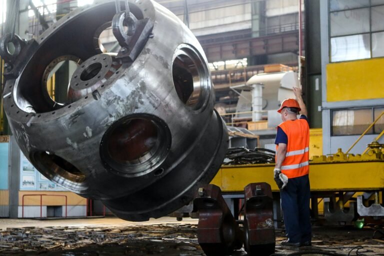 man standing in front of gray metal machine part