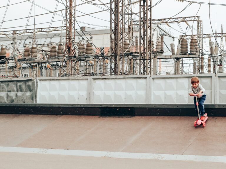 little child practicing kick scooter near power plant