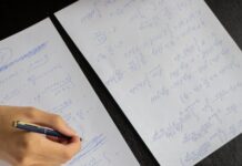 student writing in papers with homework task