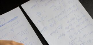 student writing in papers with homework task