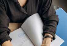 person holding black calculator while using laptop