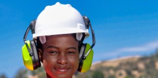 handywoman in reflective vest and white hardhat
