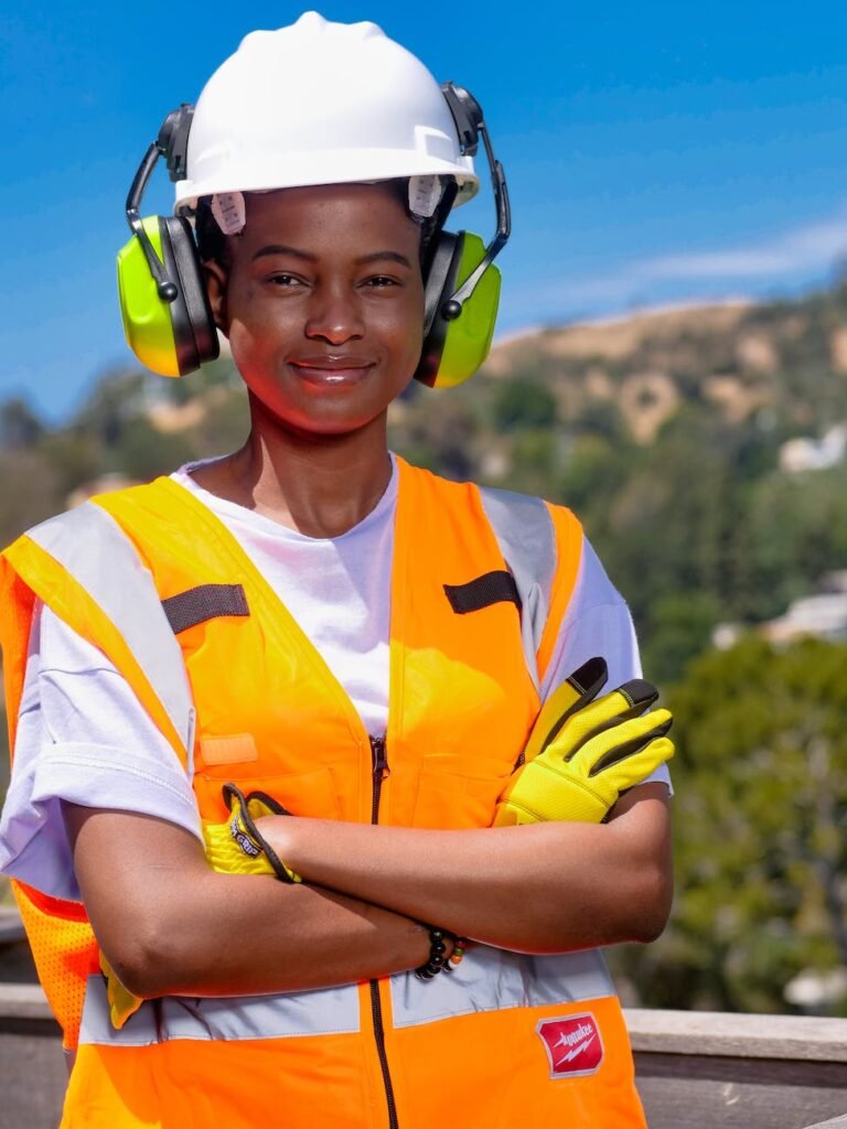 handywoman in reflective vest and white hardhat