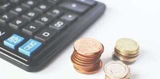 gold colored coins near calculator