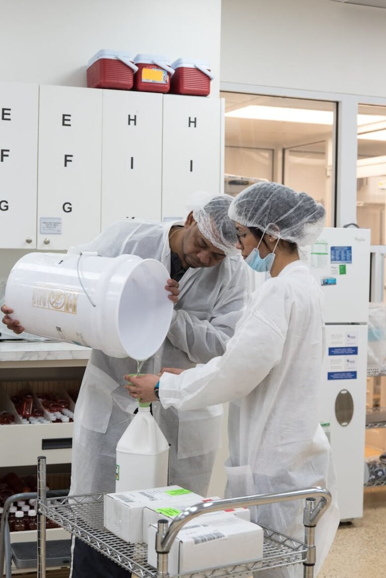 ethnic laboratory workers pouring liquid from bucket into bottle