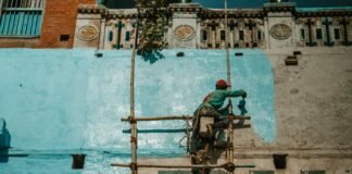man painting the facade of a building
