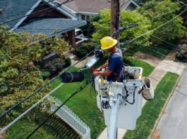 photography of man repairing electrical wires