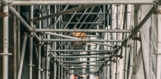 man standing beside pipes