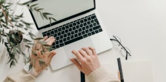 person in beige long sleeve shirt using macbook pro