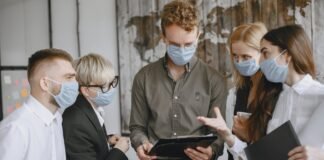 group of people talking in office wearing masks