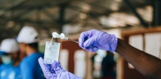 diverse people in medical gloves performing experiment