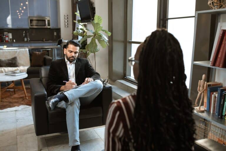 man in black suit sitting signing a contract