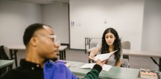 student passing the test paper to another student
