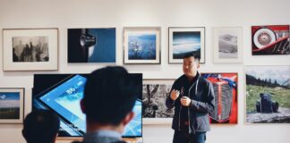 man beside flat screen television with photos background