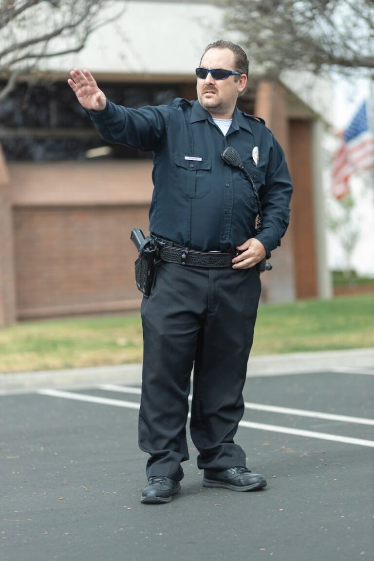 a policeman in black uniform standing on the road