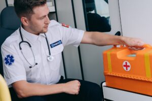 a man sitting while holding a first aid kit