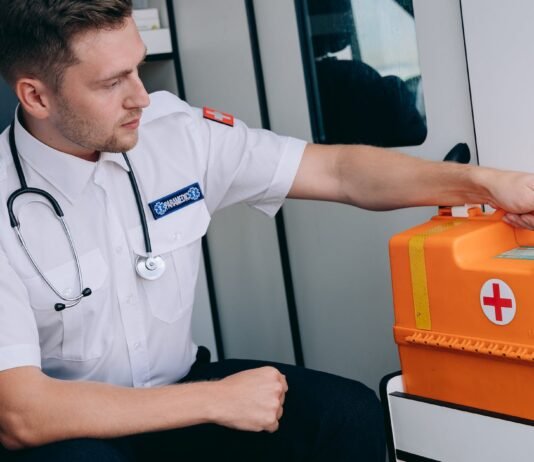 a man sitting while holding a first aid kit