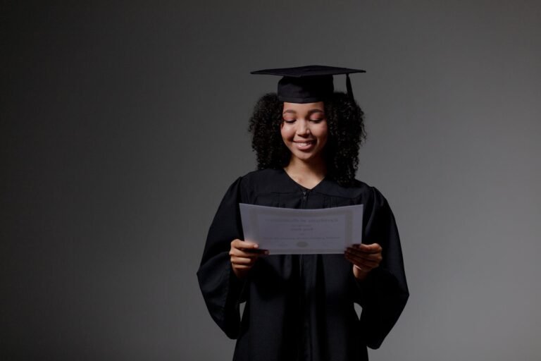 curly haired graduate student holding certificate