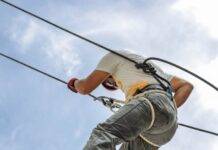 man wearing harness going down building