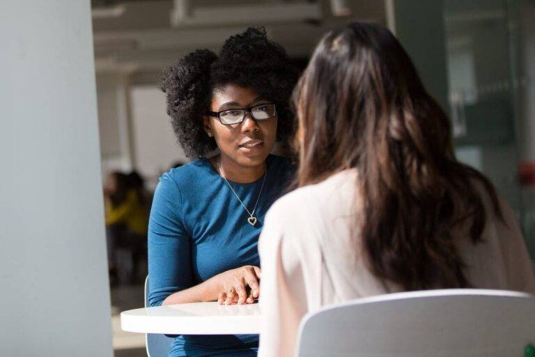woman wearing blue top beside table