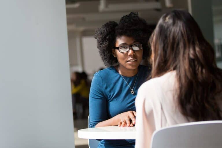 woman wearing blue top beside table