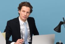 man sitting with laptop computer on desk and lamp