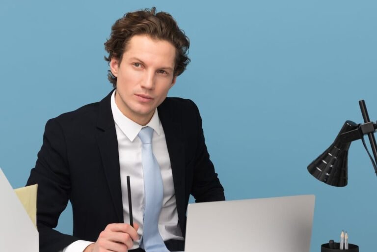 man sitting with laptop computer on desk and lamp