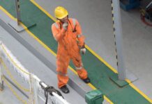 worker in uniform and helmet on road