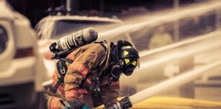 firefighter holding hose with water flowing