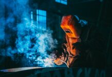 person welding wearing a prootective metal mask