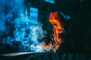 person welding wearing a prootective metal mask