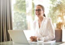 laughing businesswoman working in office with laptop