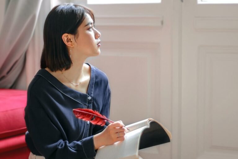 thoughtful woman writing in notebook at home