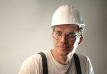 smiling male worker in construction helmet in studio