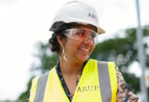 photo of female engineer wearing hard hat and yellow vest