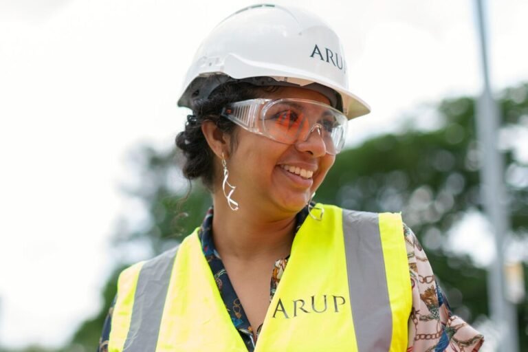 photo of female engineer wearing hard hat and yellow vest