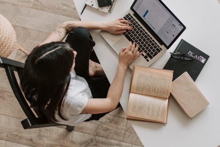 young lady typing on keyboard of laptop in living room