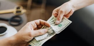 hands holding us dollar bills