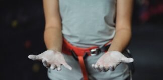 faceless climber showing hands in chalk before training