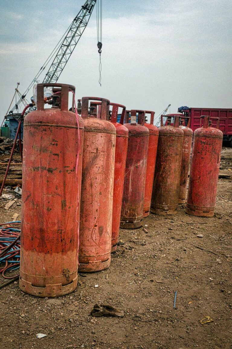 old gas tanks placed on dry ground in daytime