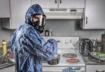 male chemist in protective respirator and suit in kitchen
