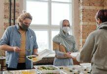 volunteers giving out meals wearing face masks