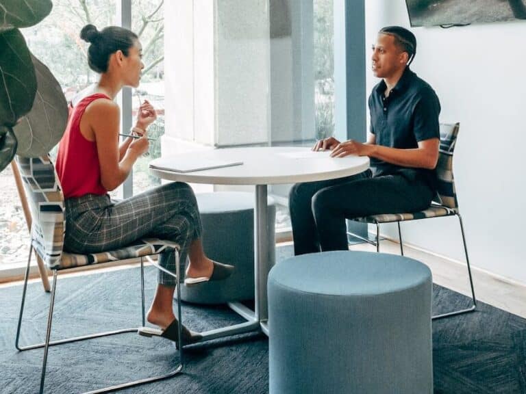 a man and woman sitting on the chair while looking at each other