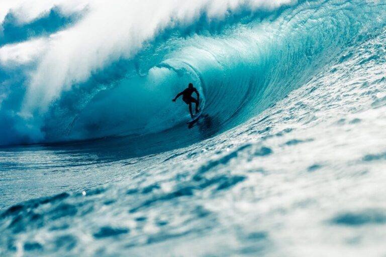 man riding surfboard in wavy ocean