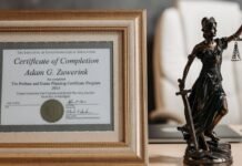 a certificate and lady justice figurine on table