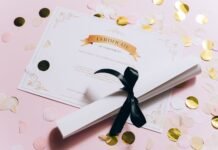 rolled white paper and a certificate on a pink surface